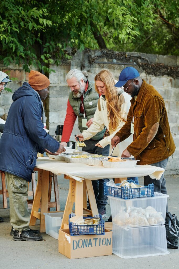 Volunteers feeding homeless people with food